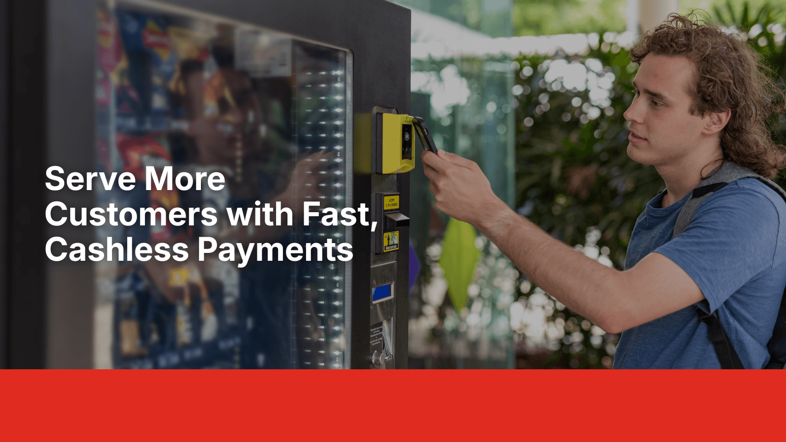 Young man tapping his phone to make a cashless payment at a vending machine, demonstrating Enroute Vending modern tap and card payment systems.